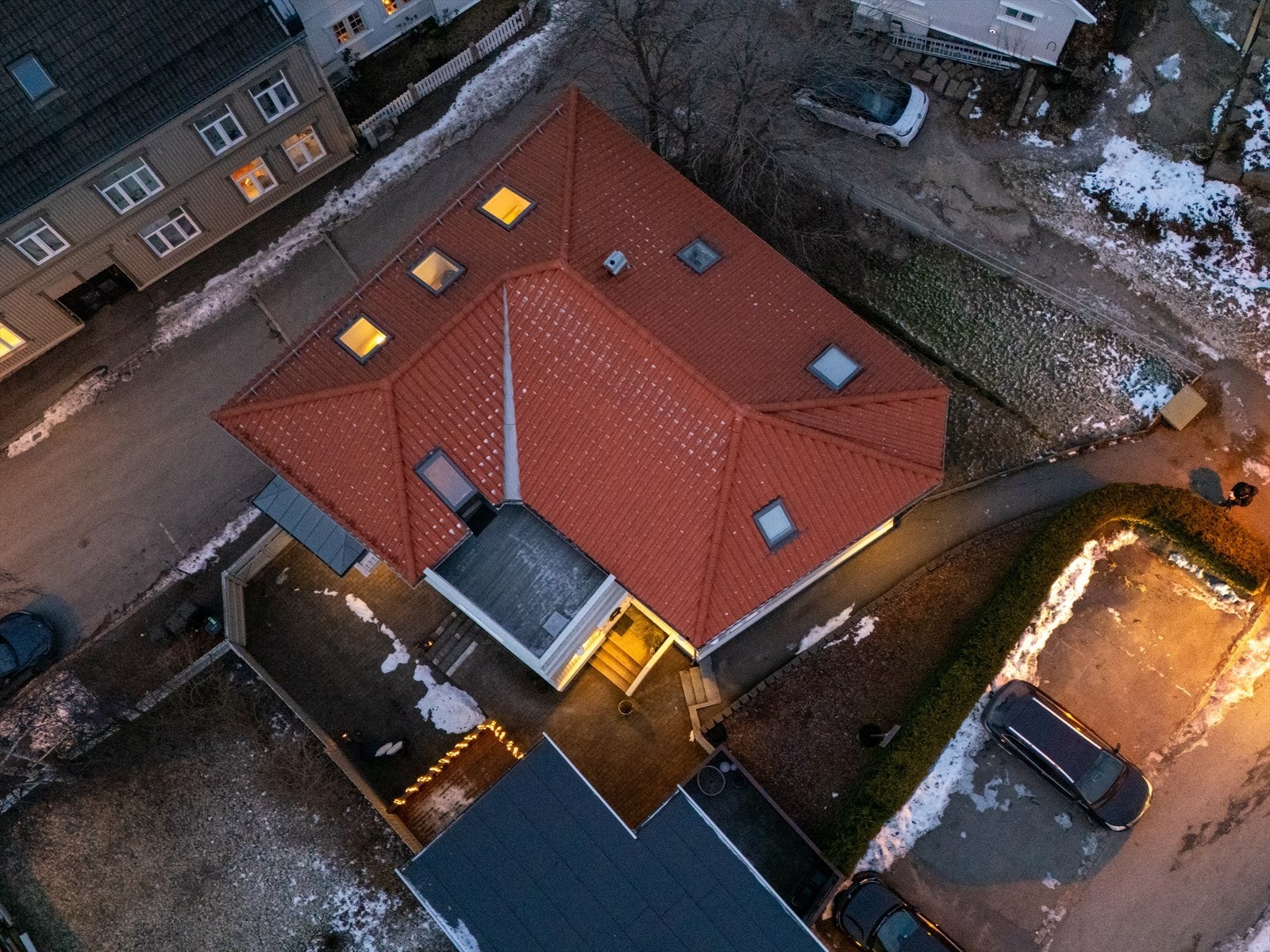 En asfaltert sti passerer gressplen og bed, ned til inngangsdøren og den romslige, steinsatte gårdsplassen. Alt er svært ryddig og omhyggelig utformet. Fellesområdet er skjermet og byr på god plass til å anrette enkle sittegrupper. Galleribilde