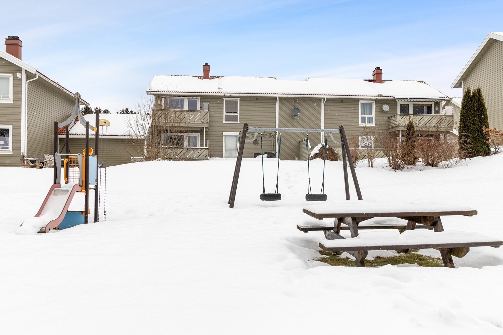 Fellesområdet har lekeplass med lekeapparater og sittebenker. Galleribilde