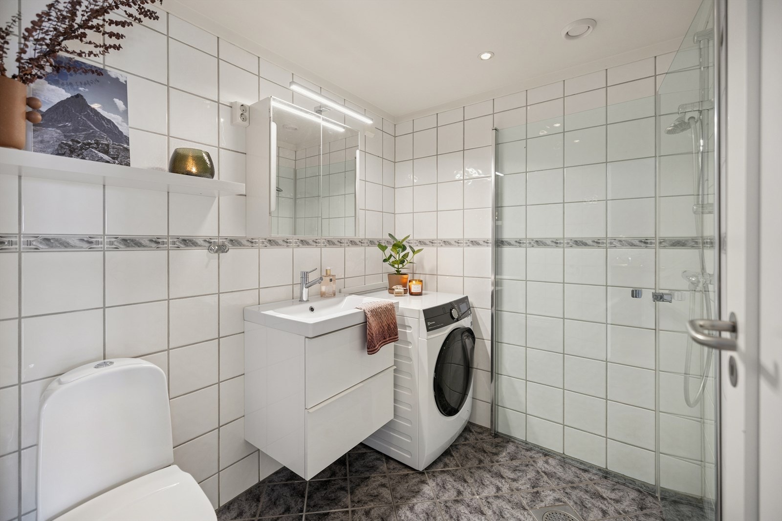 Badet har flislagte overflater på både vegger og gulv, med varme i gulvet. I himlingen er det montert downlights. Galleribilde