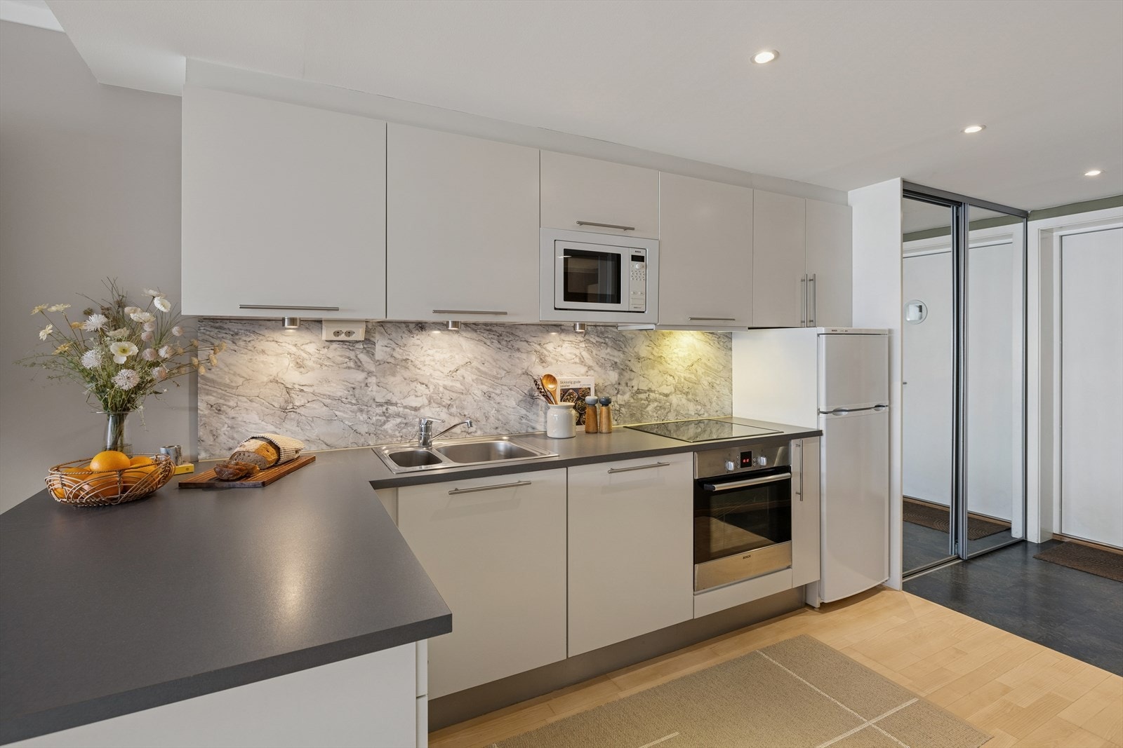 Innredning med glatte fronter, laminerte skrog og en laminert benkeplate med nedfelt kjøkkenkum. Galleribilde