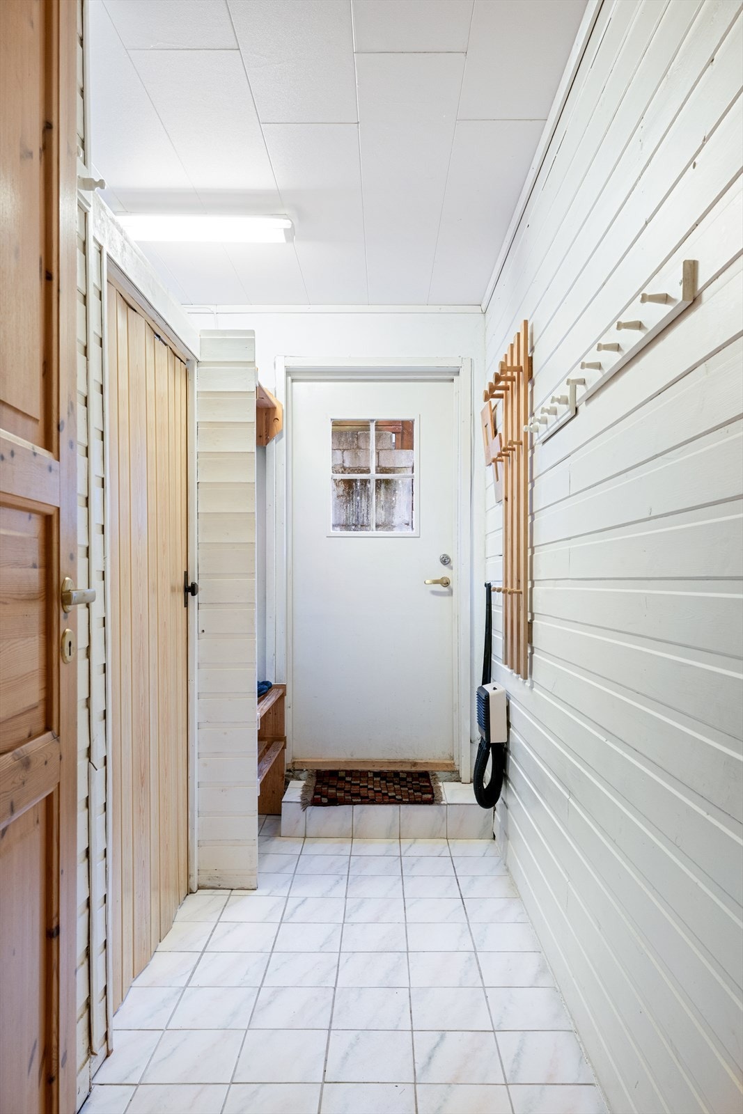 Gang i sokkeletasjen, med dør ut til hage / utearealet. Galleribilde