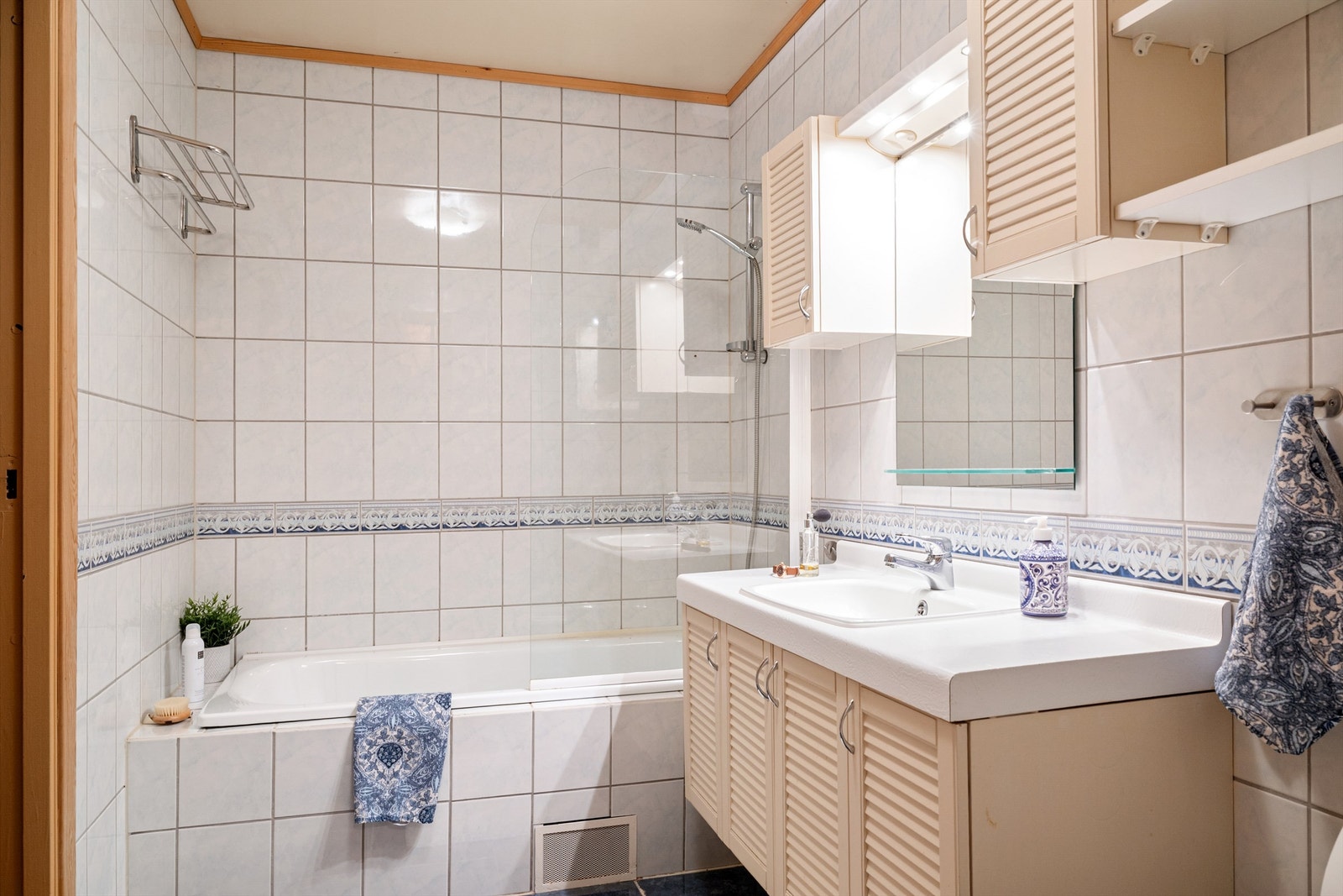 Bad med badekar i sokkeletasjen. Det er montert dusjvegg i glass på badekaret. Galleribilde