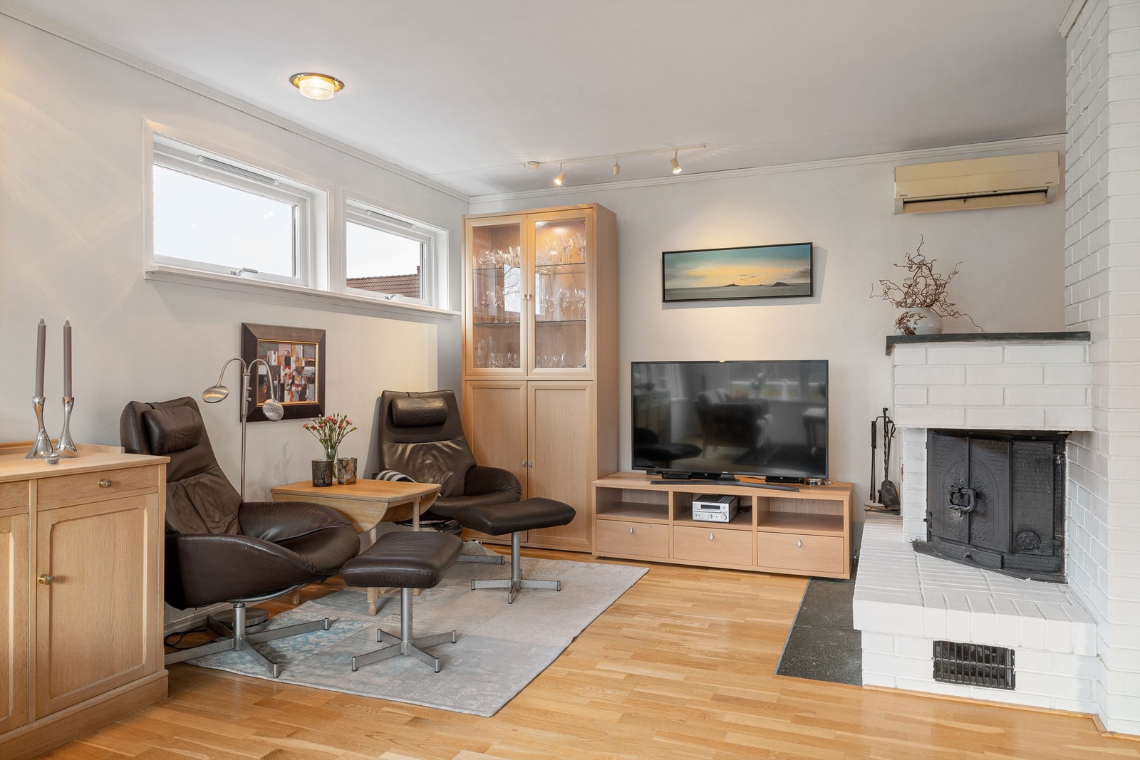 Stue. Med herlig peis, kan det både fyres for litt ekstra varme på kalde vinterdager, eller åpne opp for slik man kan kose seg foran levende flammer. Det er ellers også varmepumpe i stuen, som man kan se opp til høyre i bildet. Galleribilde