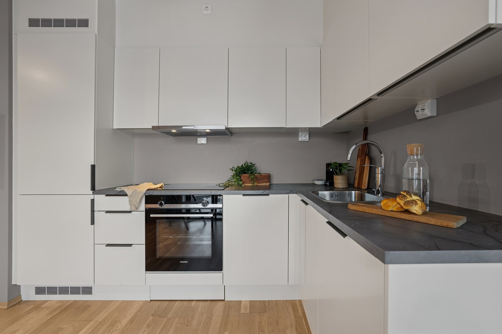 Moderne kjøkkeninnredning fra byggeåret med glatte fronter og integrerte hvitevarer. Galleribilde