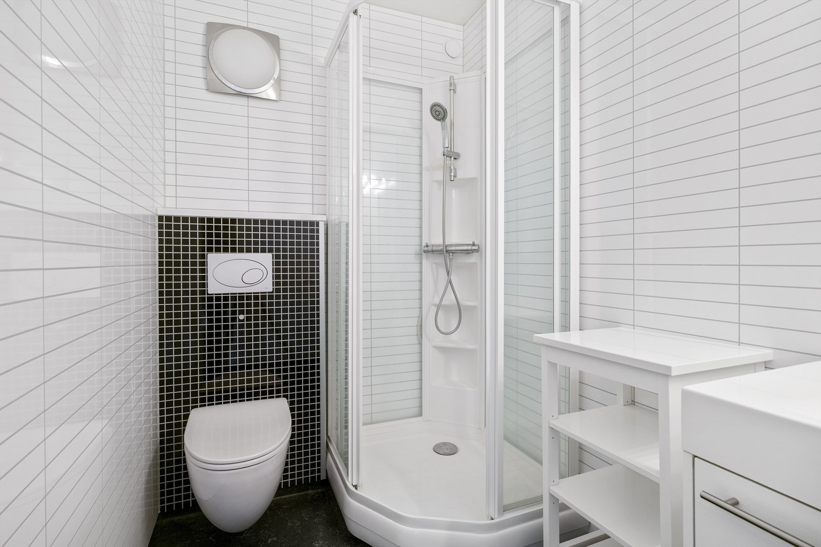 Her er det varmekabler i gulv. Innredet med servant i møbel, vegghengt toalett og dusjkabinett. Galleribilde