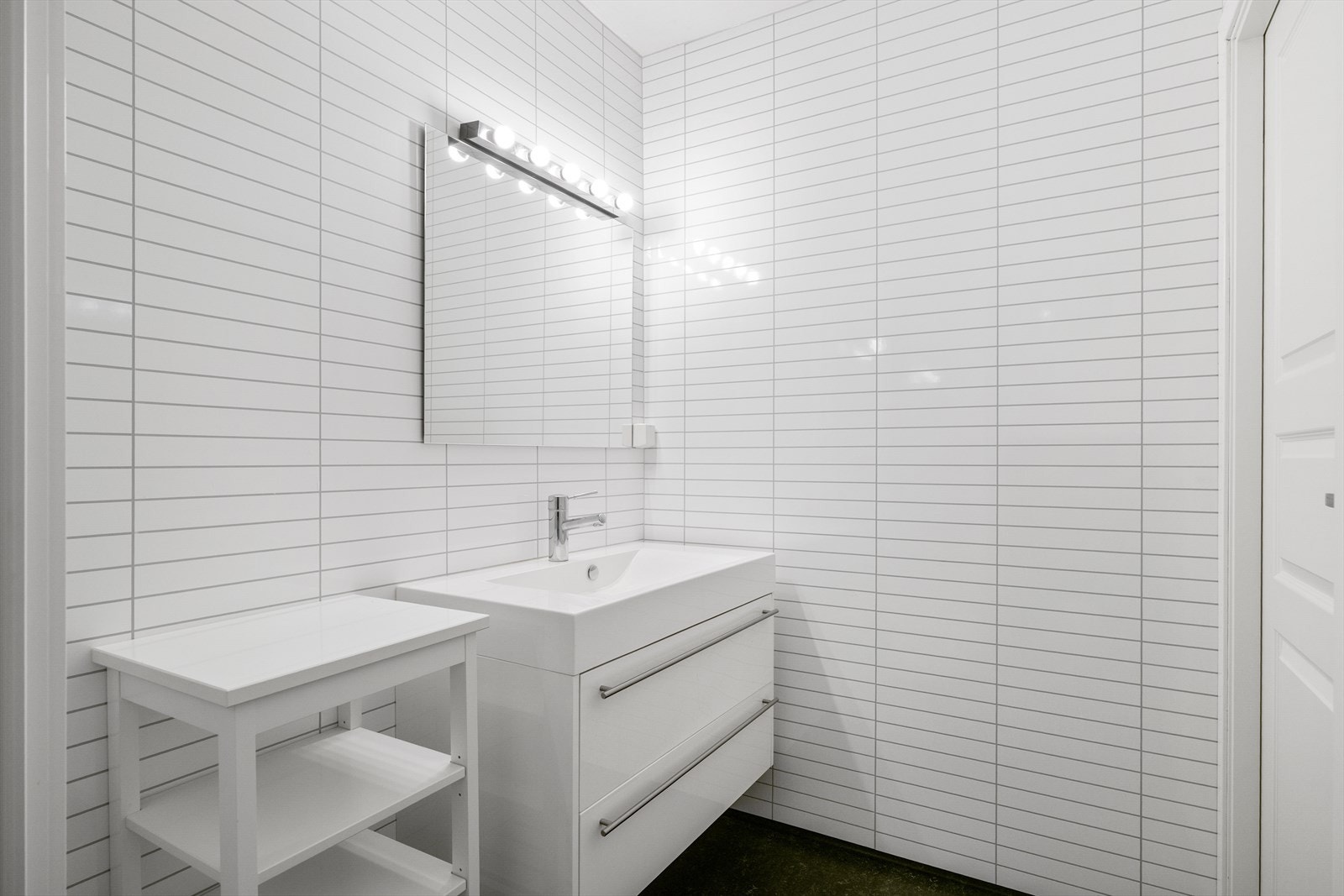 Leilighetens bad er fra 2013 og har vinylbelegg på gulv og vegger med baderomsplater. Galleribilde