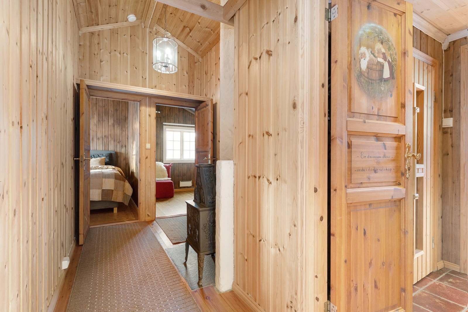 Fra entrèen kommer man inn i en gang som deler av oppholdsrommene fra soverom og baderomsavdeling. Legg merke til den praktiske hemsen og høye himlingen, perfekt for ekstra lagringsplass. Galleribilde