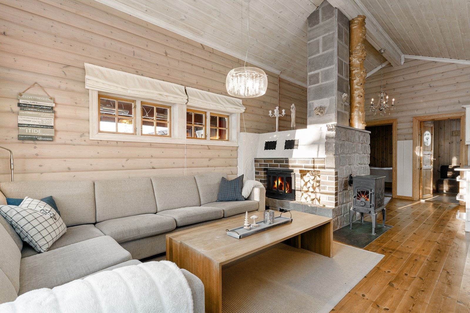 Videre har man luksusen av å både ha en lukket peisinnsats, egen nisje for veden, og en ekstra vedovn for mer effektiv oppvarming. Pipe og murvegg er forblendet i stein og skifer. Galleribilde
