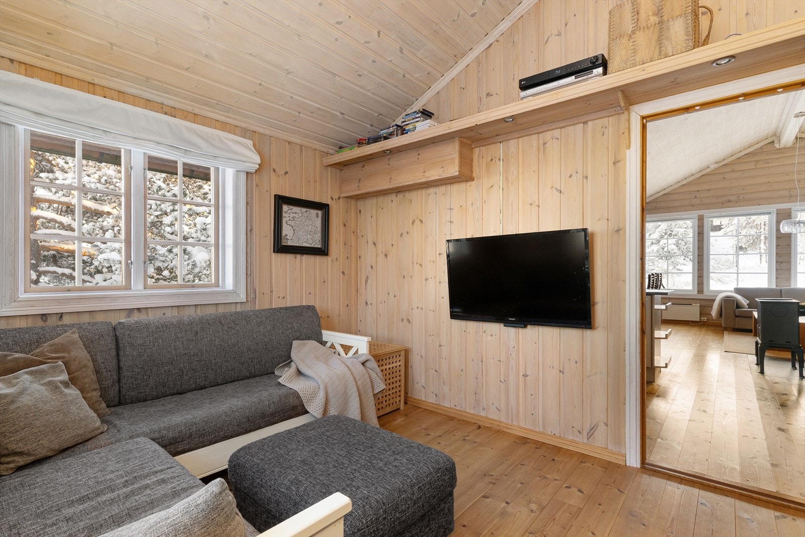 Inn fra stuen er det ene soverommet tatt i bruk som en egen TV-stue. Perfekt for småbarnsfamilier, eller om man ønsker TV-en ut av stua. Galleribilde