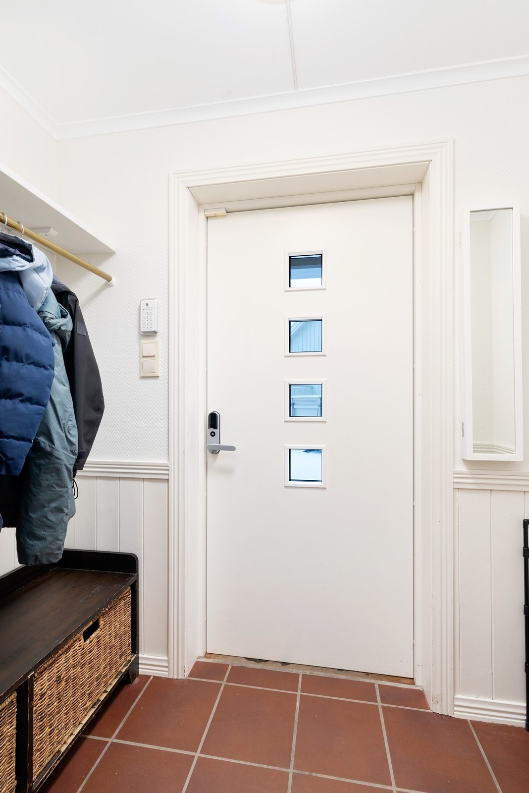 Entré med plass til oppbevaring av yttertøy og sko. Fliser på gulv med varmekabler. Panel/tapet på veggene. Galleribilde