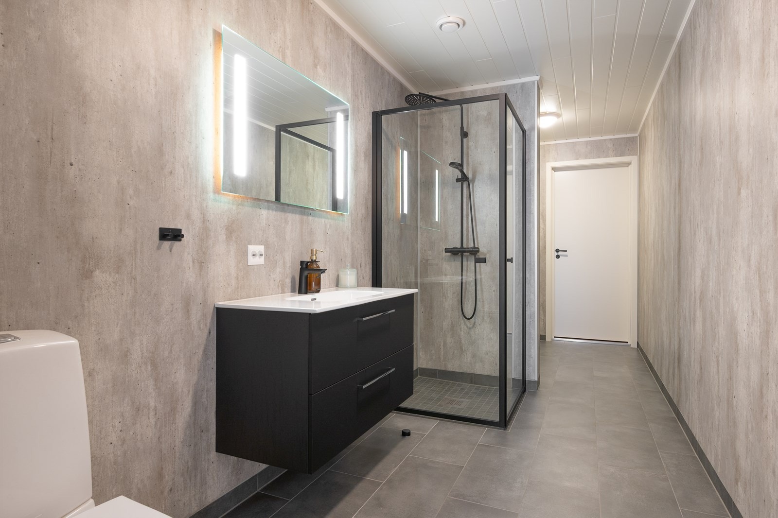 Badet i 1.etasje er pent utført med sorte detaljer og moderne løsninger Galleribilde
