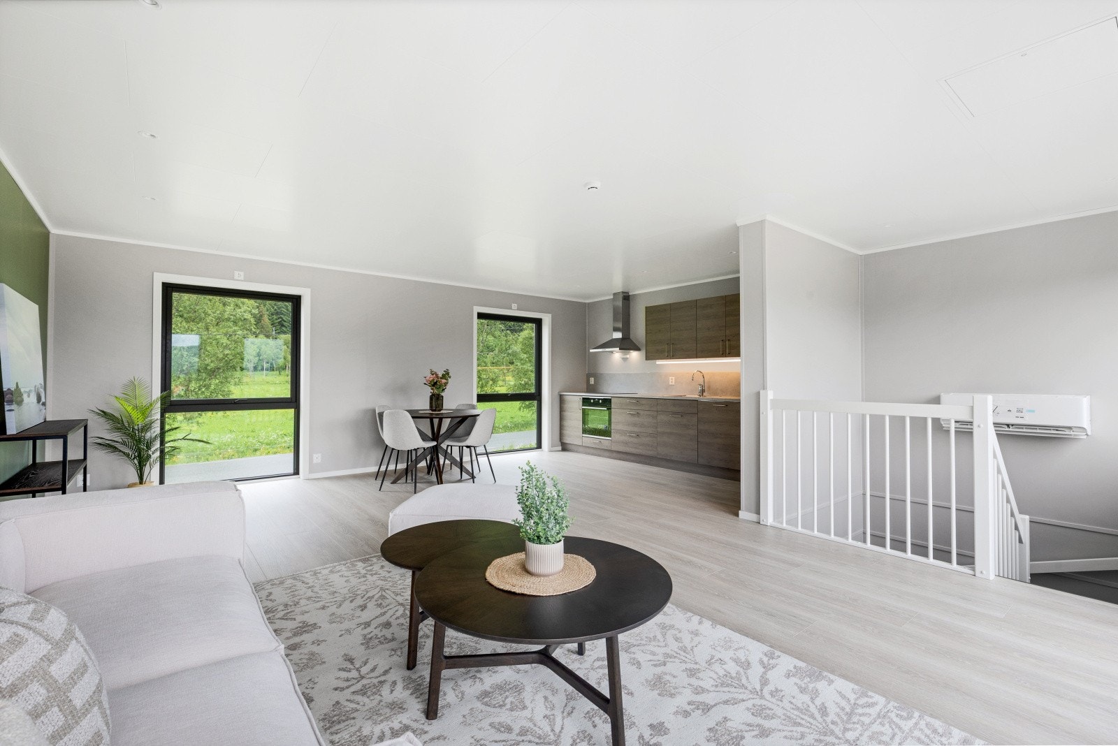 Lys og luftig stue med utsikt. Store vinduer og åpen løsning mellom stue og kjøkken gir flott romfølelse Galleribilde