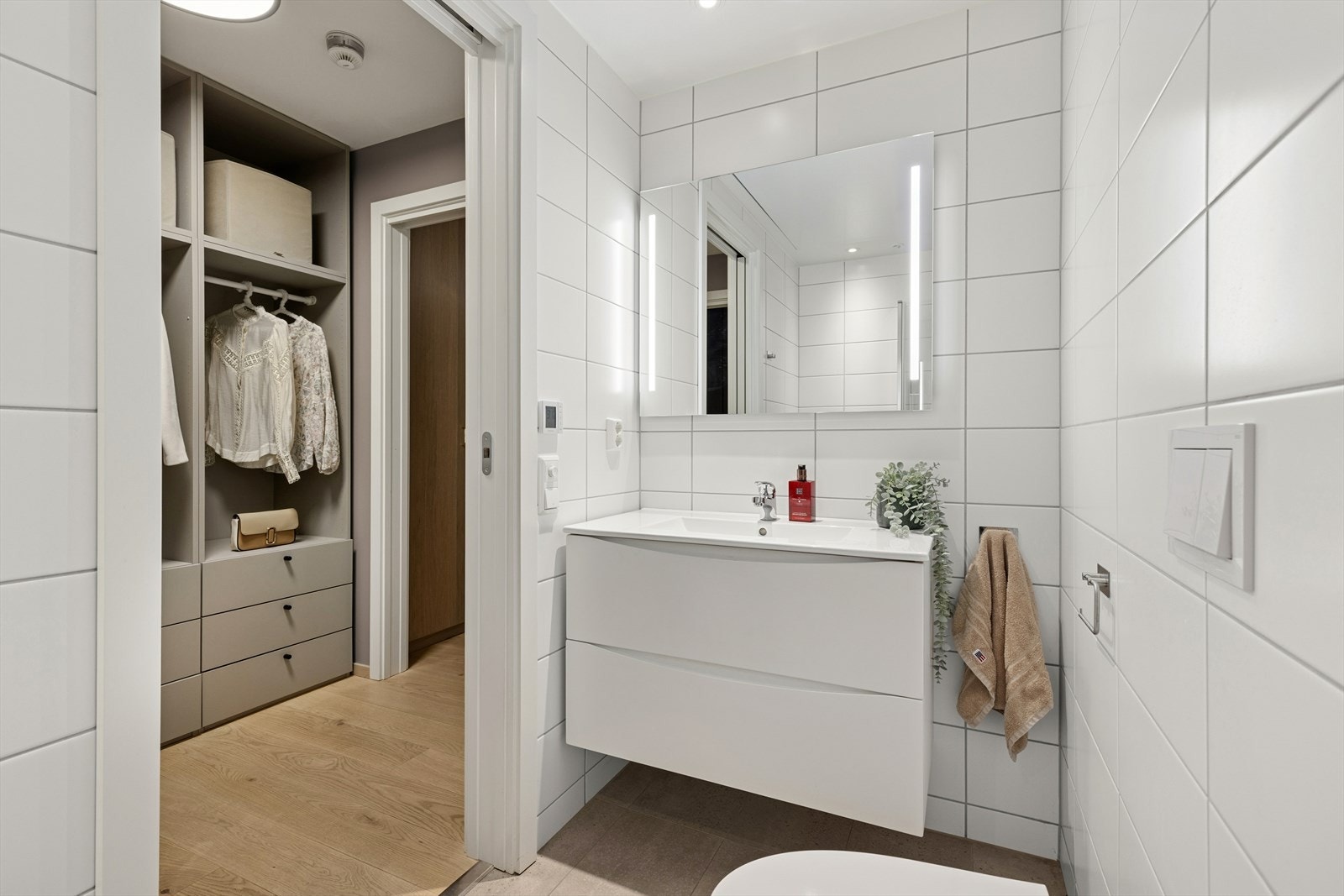 Leilighetens andre bad ligger i praktisk tilknytning til hovedsoverommet og walk-in garderoben. Det har flislagte overflater og behagelige varmekabler i gulvet. Galleribilde