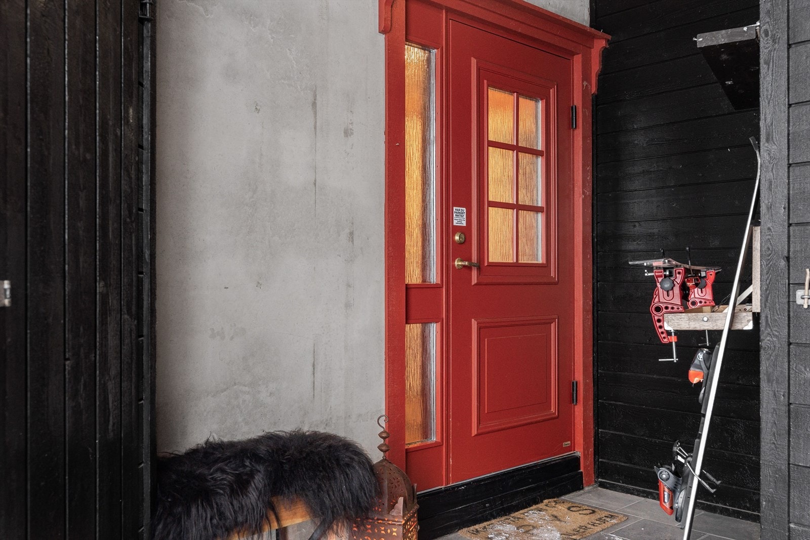 Overbygd inngangsparti, med skibod til venstre og innebygget smørestativ til høyre. Galleribilde