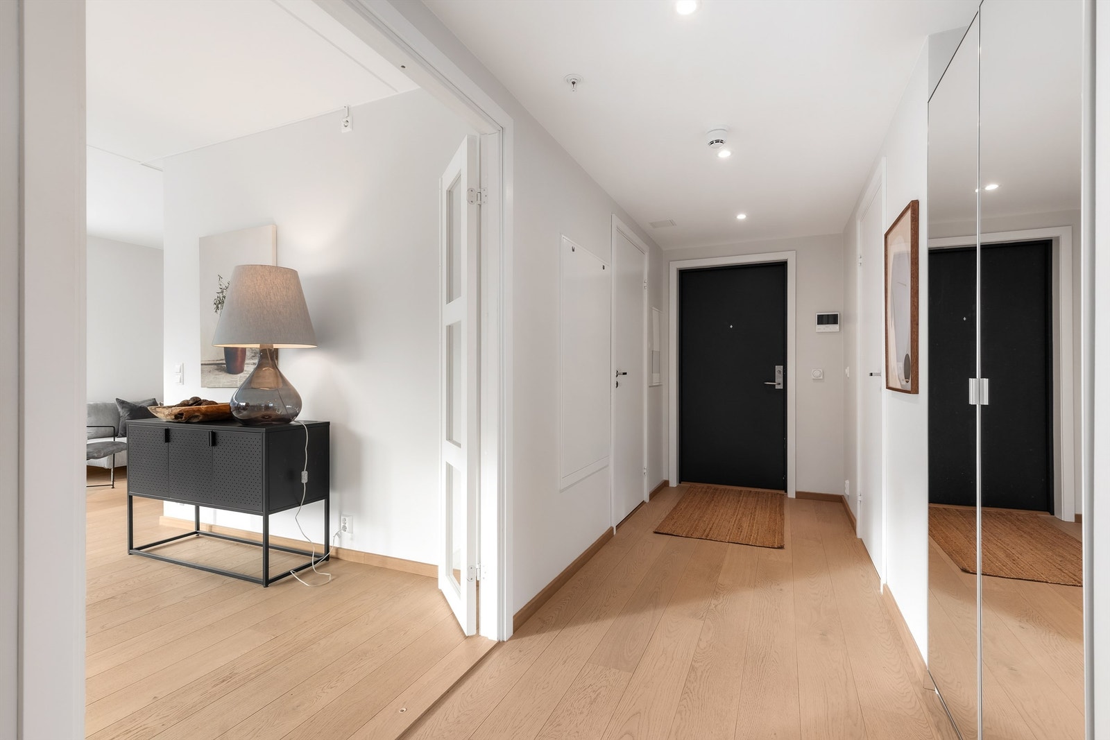 Romslig entré med plass til garderobeskap for oppbevaring av ytterklær og sko. Fra entreen kommer man videre til badet, begge soverommene, toalettrommet og stuen/kjøkkenet. Galleribilde