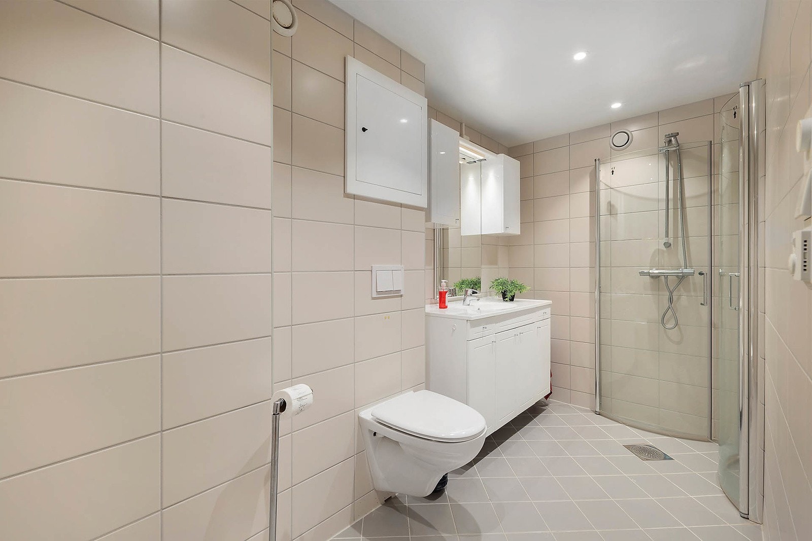 Badet består av servant m/ underskap, speil med overlys, veggskap, dusjhjørne og vegghengt klosett. Galleribilde