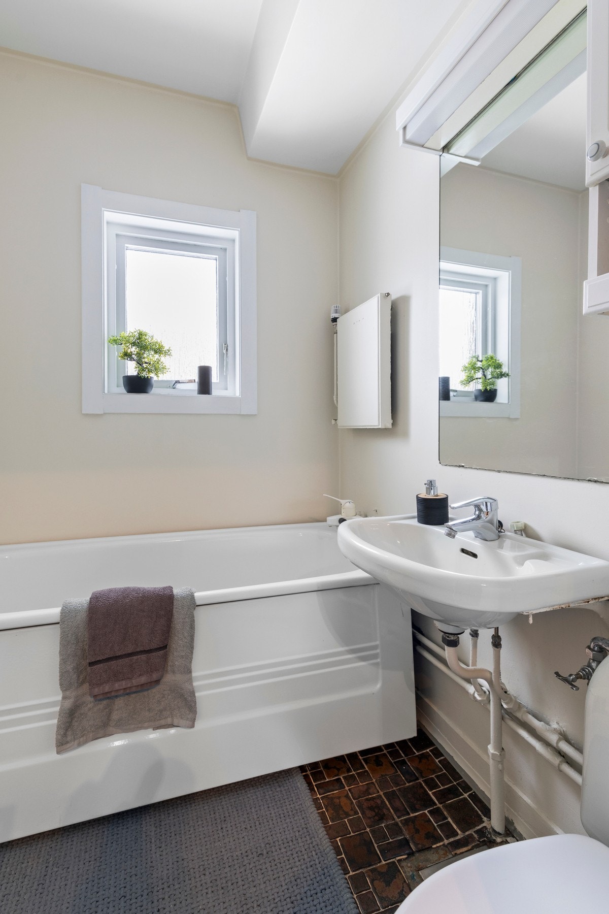 Nyere innredning med badekar, vegghengt servant og gulvstående toalett Galleribilde