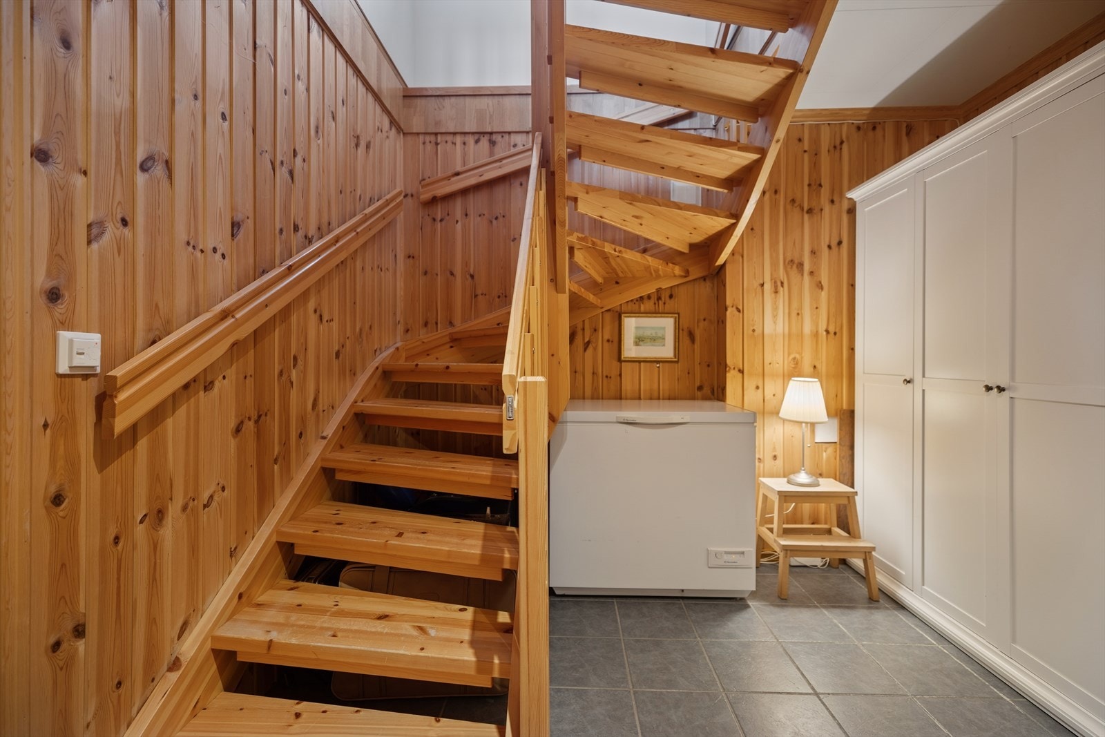 Trappen leder ned fra hovedetasjen til en romslig kjeller med god takhøyde Galleribilde