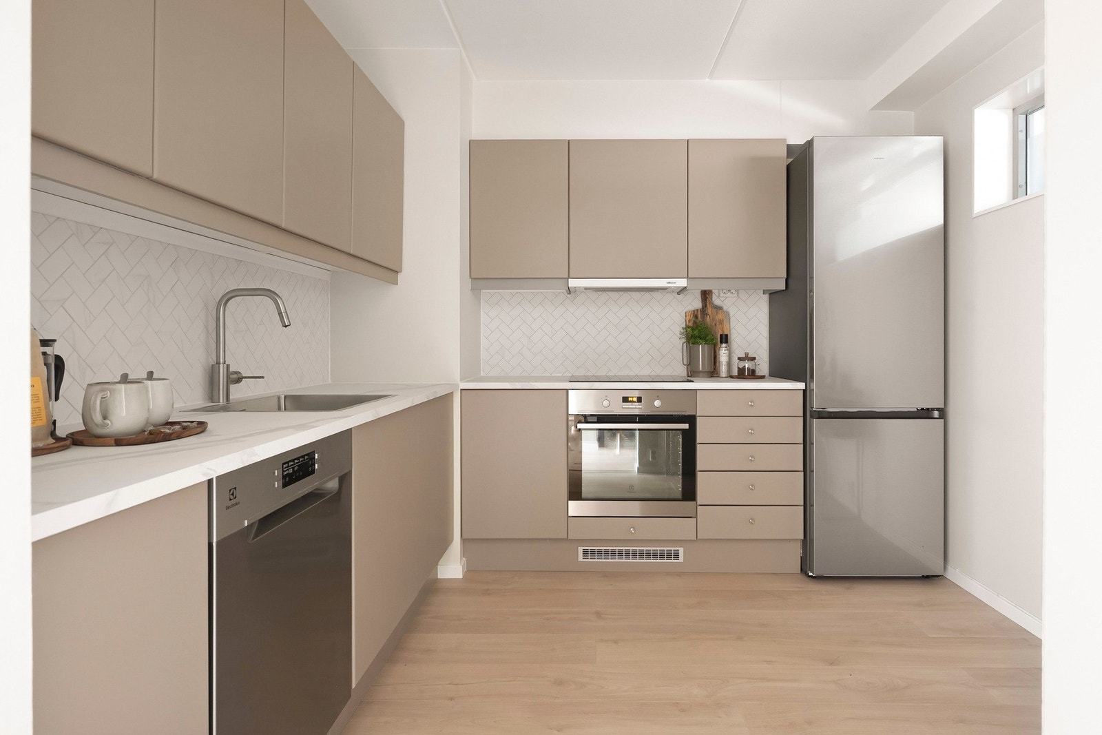 Kjøkkeninnredningen har slette, tidløse fronter og laminat benkeplate. Galleribilde