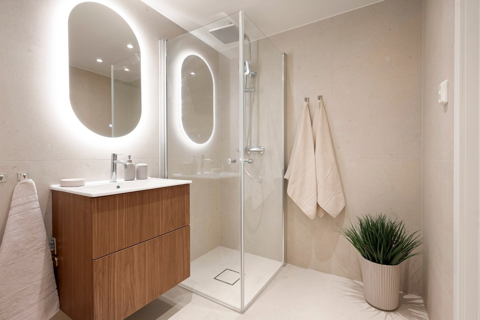 Dusjsone med innfellbare glassdører og dusjarmatur med både hånddusj og regndusj. Galleribilde