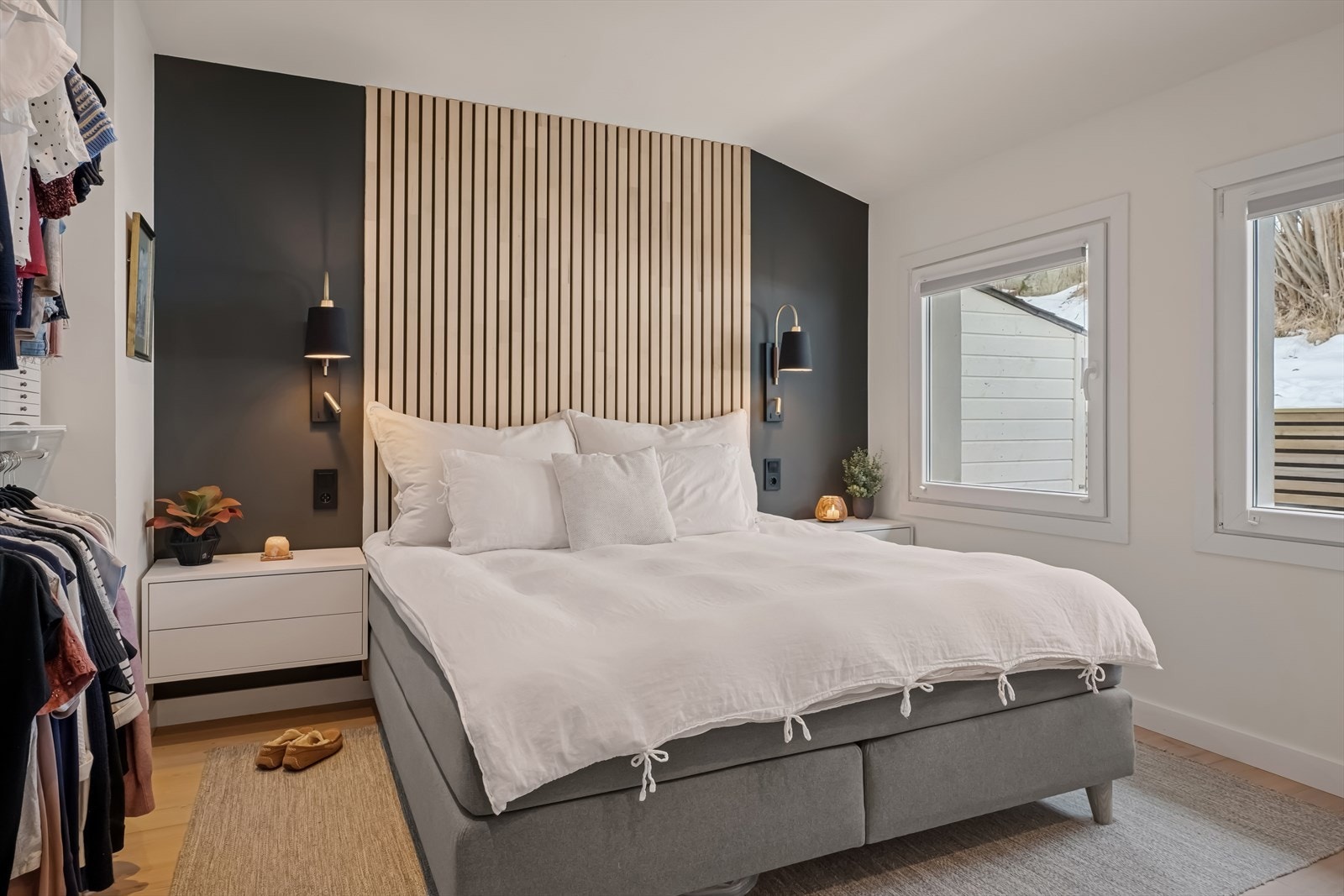 Hovedsoverommet har en elegant fondvegg i dempet sort med moderne spiler - en smakfull kontrast til de øvrig lyse veggene Galleribilde