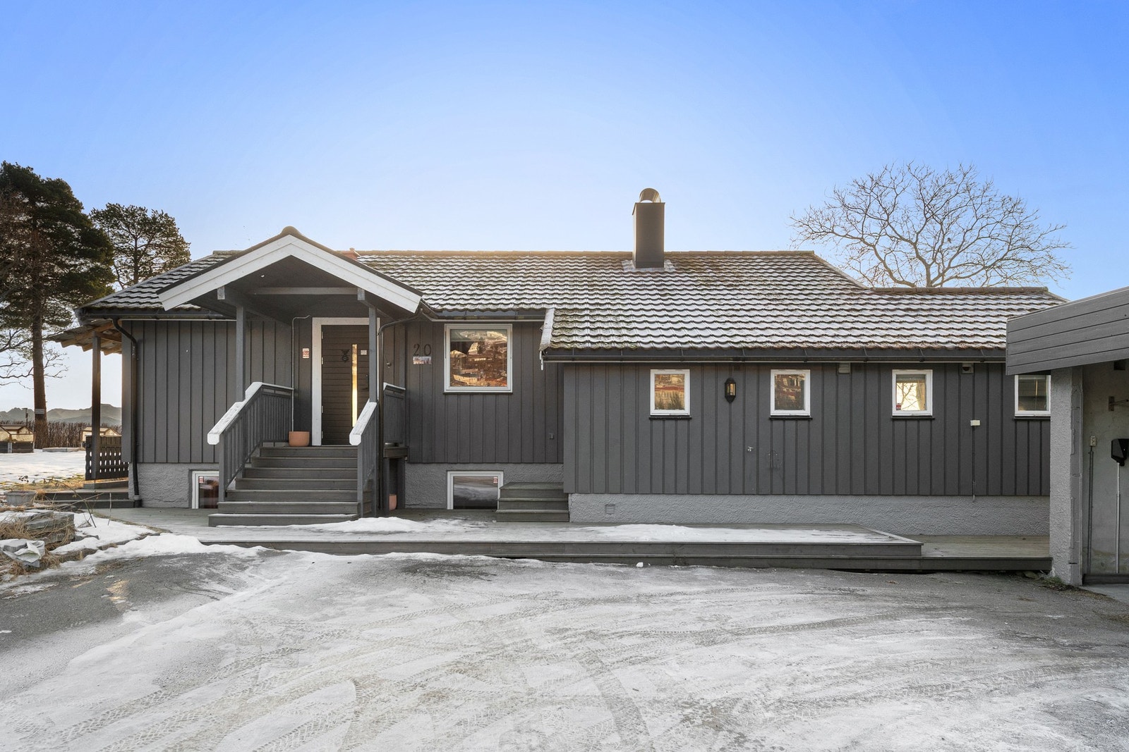 Pent opparbeidet tomt med asfaltert innkjørsel med god plass til parkering og plattinger som knyter inngangspartiene sammen Galleribilde