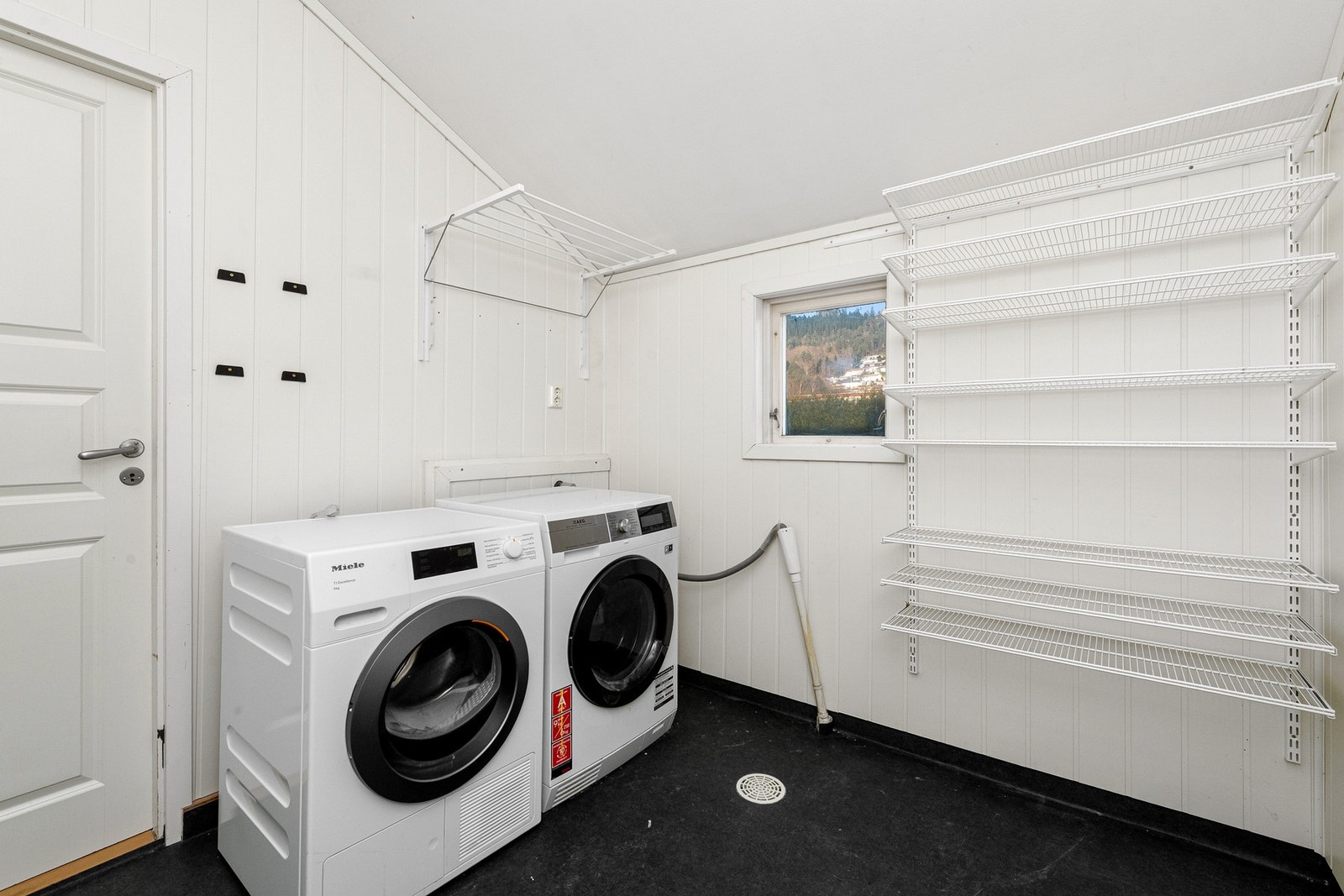 Vaskerommet ble pusset opp i 2019 og har egen inngang. Videre leder døren til venstre inn til et bad og soverom i hoveddelen. Galleribilde