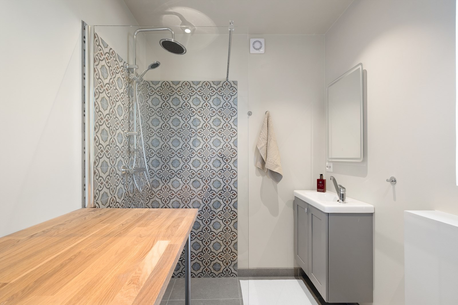 Delikat bad innredet med vegghengt toalett, servantskap med overliggende servant og vegghengt lyssatt speil. Flislagt dusjnisje med glassdør samt det er elektriske varmekabler i gulv Galleribilde