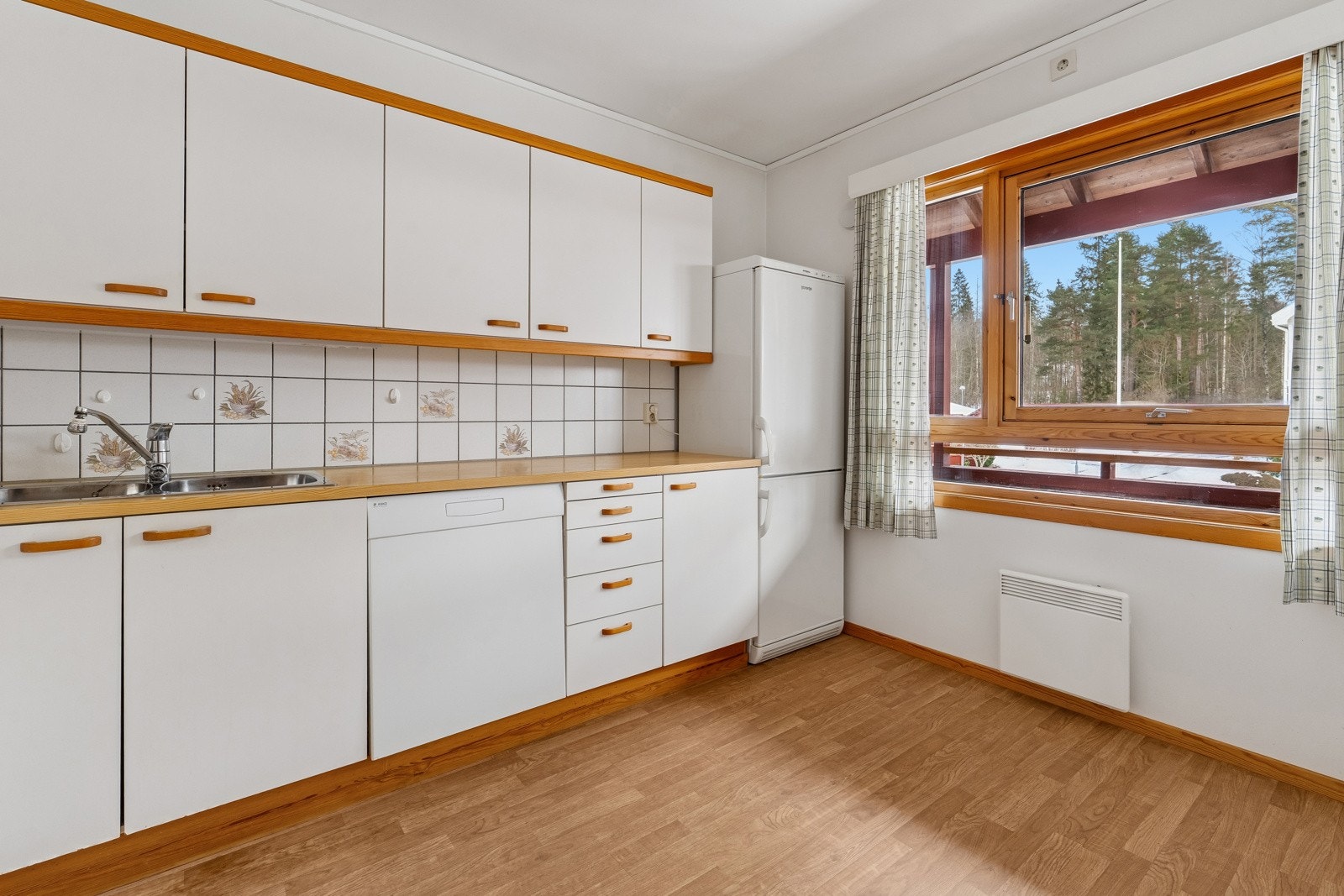 Separat romslig kjøkken med plass til kjøkkenbord ved vinduet. Galleribilde