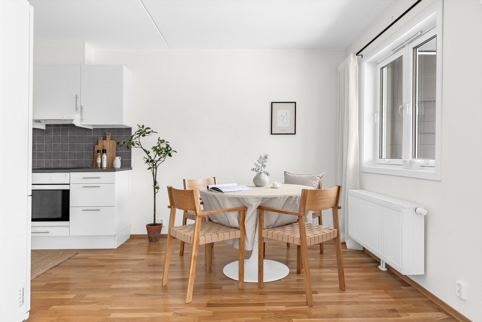 Leiligheten har en delvis åpen løsning mellom stuen og kjøkkenet, der spiseplassen markerer det naturlige skillet. Galleribilde