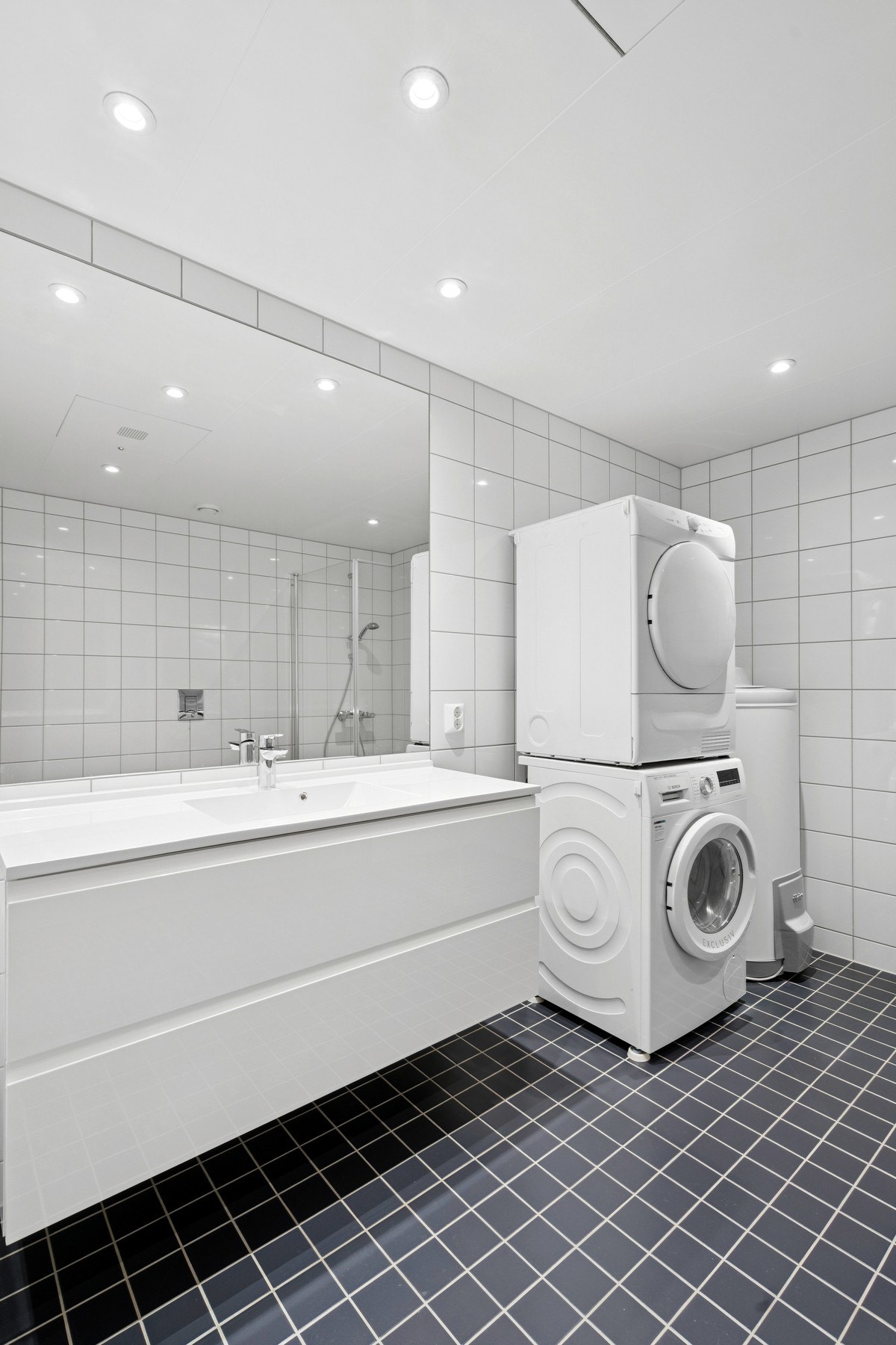 Innbydende bad med flislagte gulv og vegger, behagelig gulvvarme og heldekkende servant- Romslig og tidløst uttrykk Galleribilde