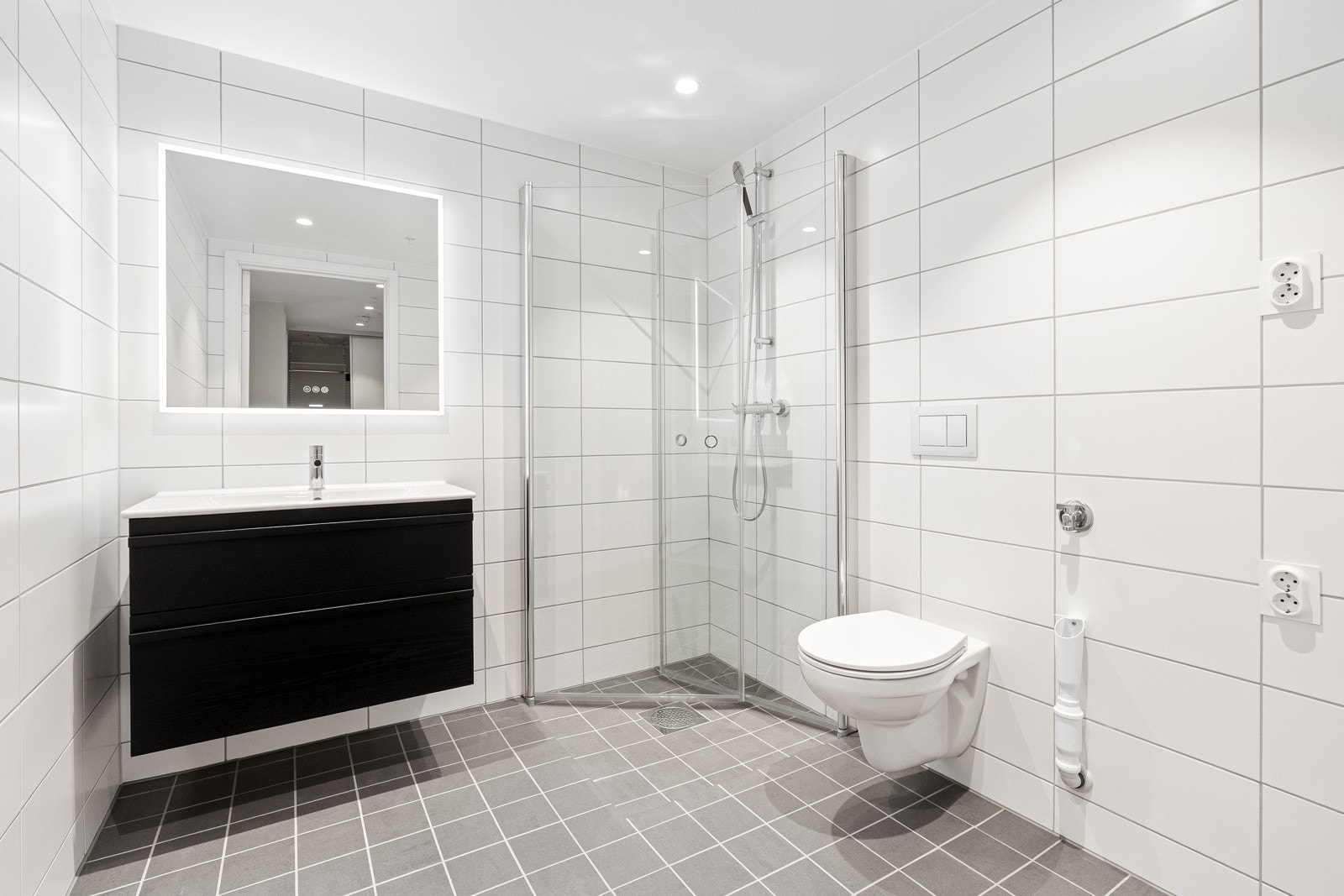 Lekkert baderom med glatt innredning, speil med belysning, servant og dusjhjørne med glassdører - gulvvarme - opplegg for vaskemaskin Galleribilde