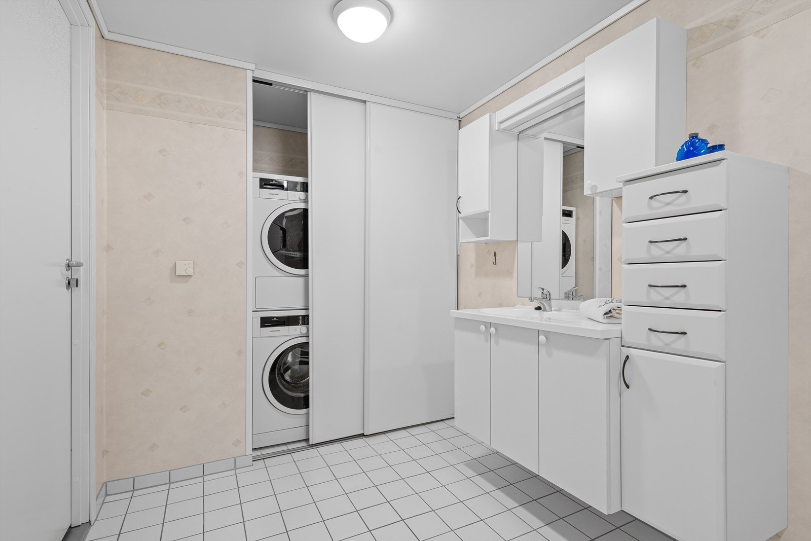 Badet har plass for vaskemaskin og tørketrommel bak skyvedører. Galleribilde
