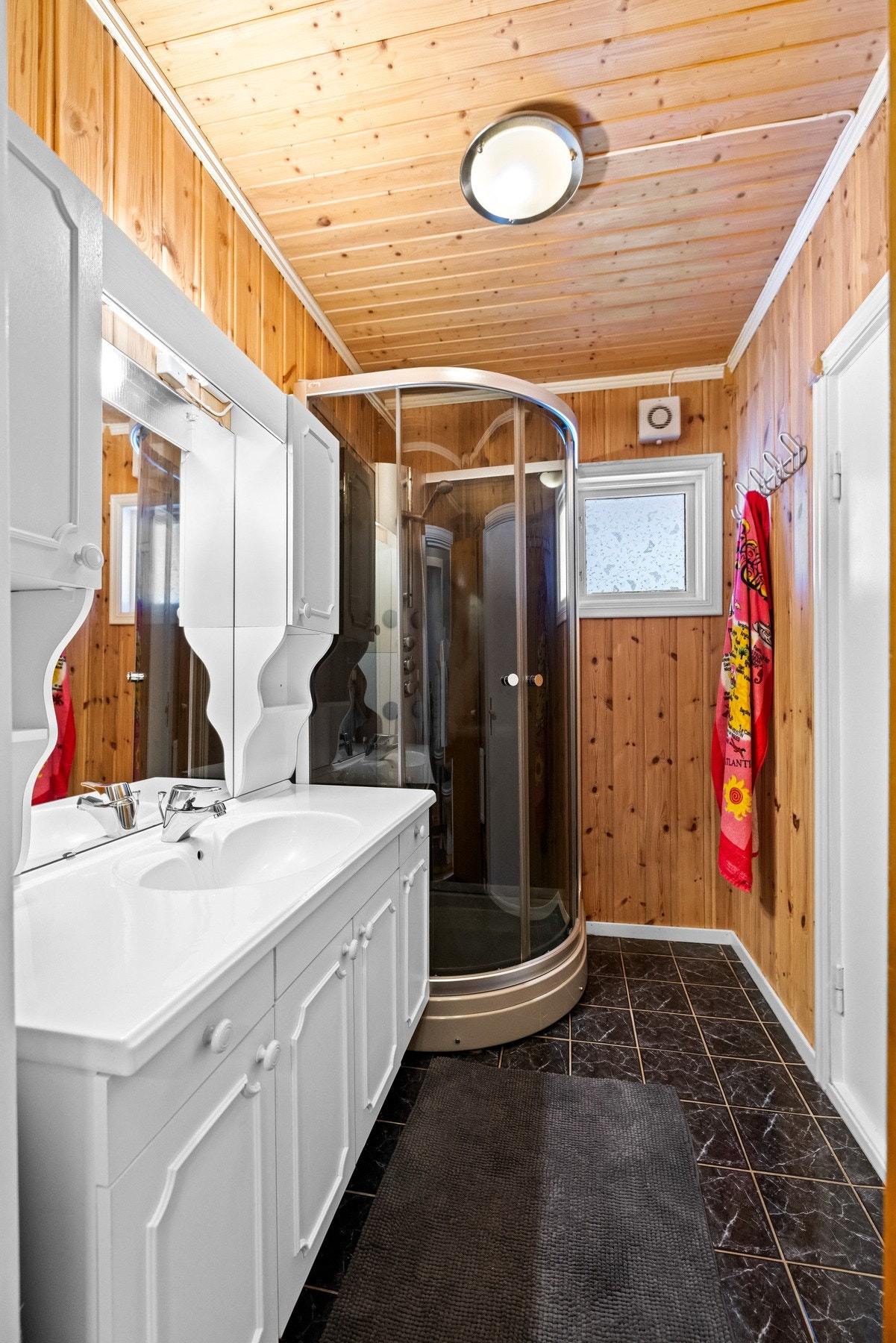 Baderommet har vegghengt servantskap med overliggende servant med ett-greps armatur og dusjkabinett. Galleribilde