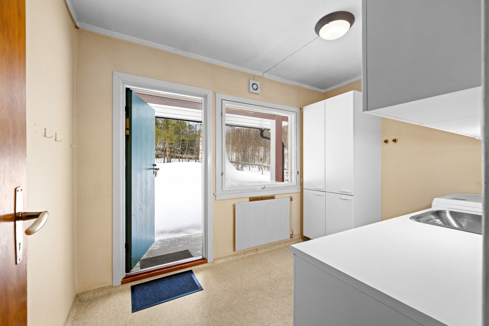 Vaskerommet ligger parallelt med kjøkkenet og har egen utgang på baksiden av huset. Galleribilde