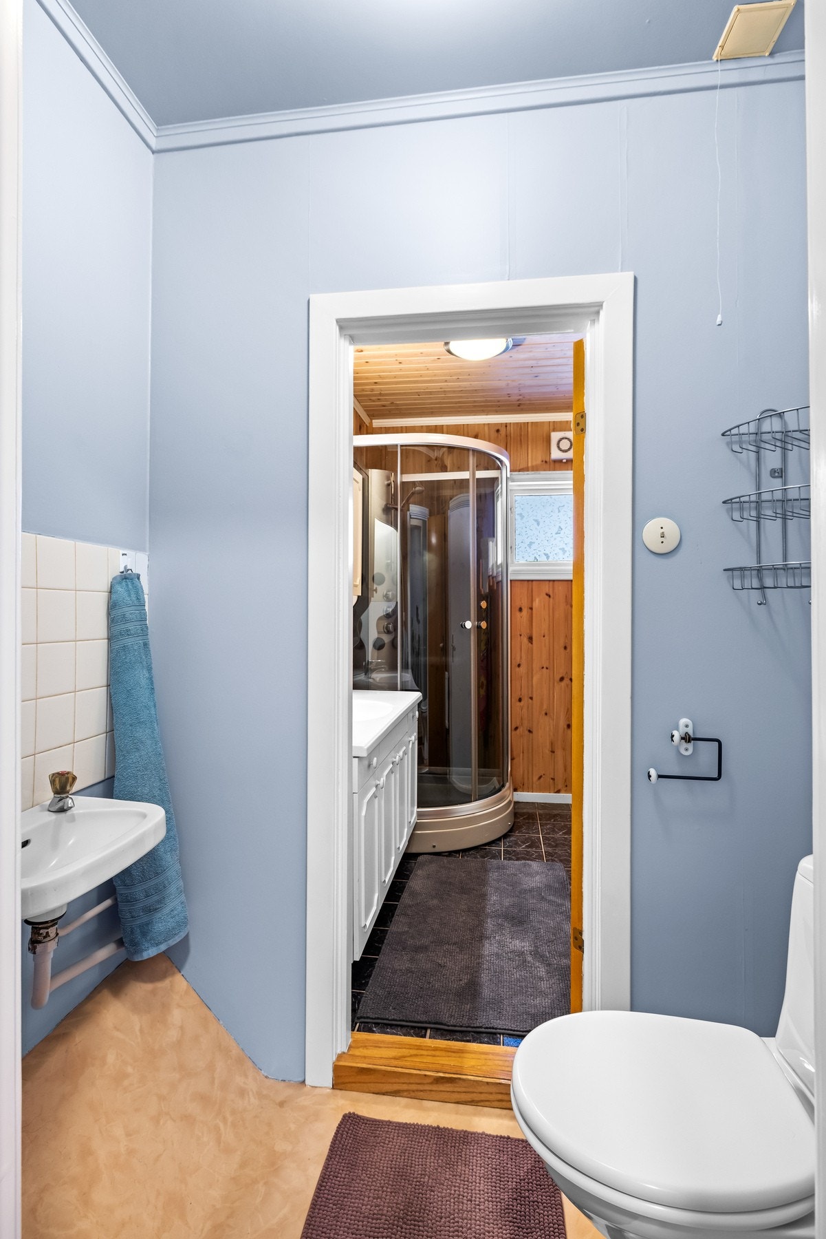 Toalettrommet er utstyrt med gulvstående toalett med vegghengt servant med ett-greps armatur. Galleribilde