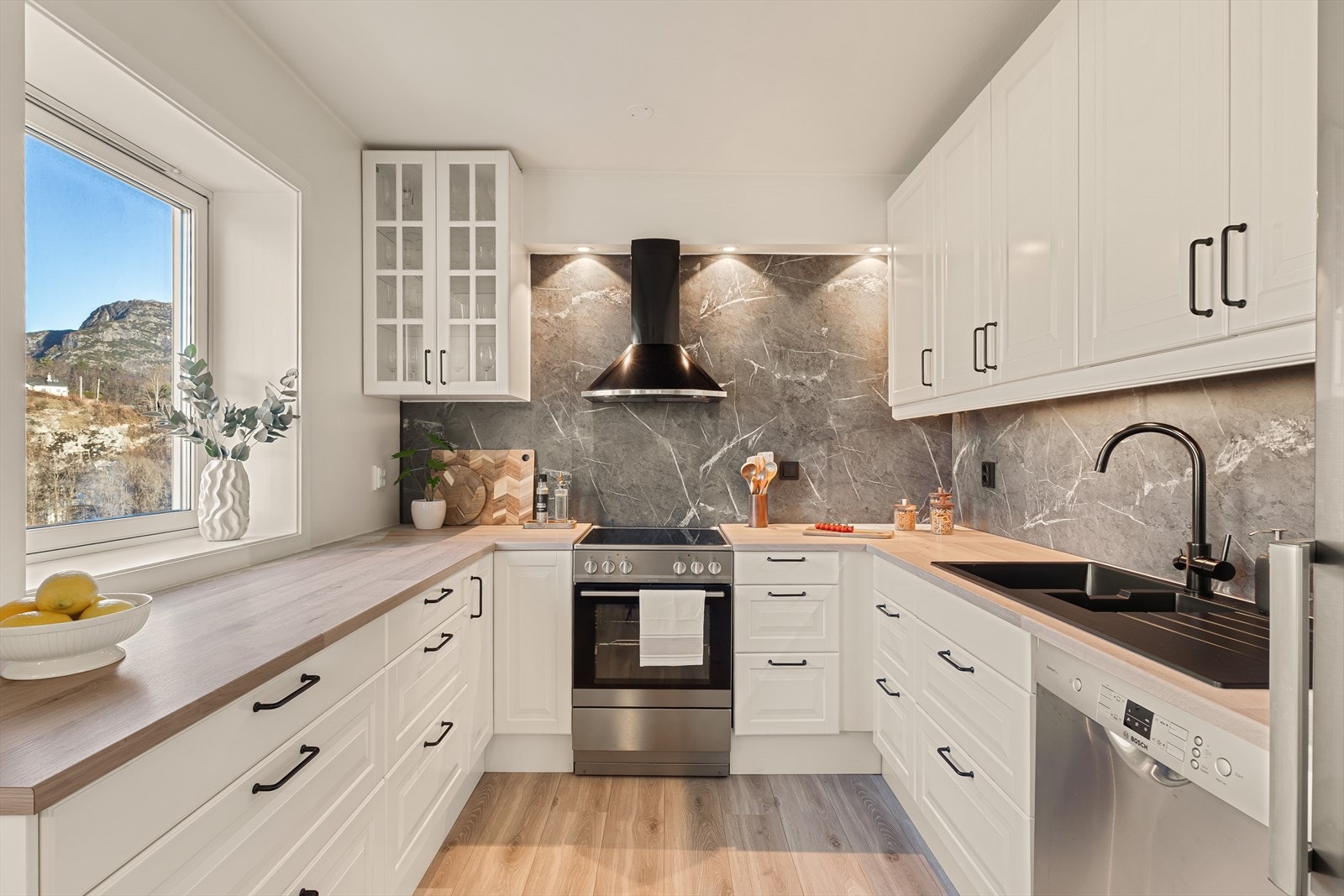 Kjøkkeninnredningen har laminat benkeplate med tilhørende skvettplate på vegg over benkeplaten. Galleribilde