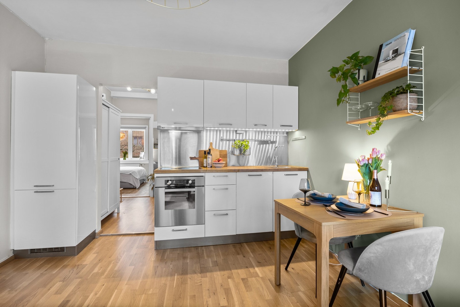 Pent kjøkken med hvite, slette fronter og laminert benkeplate. Galleribilde