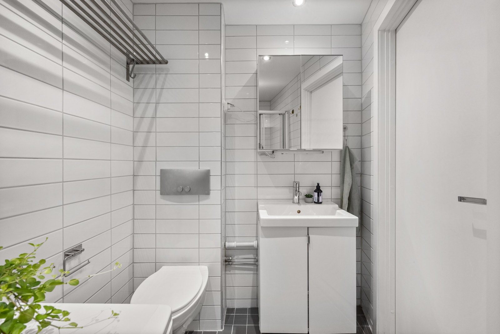 Badet er innredet med servantseksjon med skap, overskap med speil, samt vegghengt toalett. Galleribilde