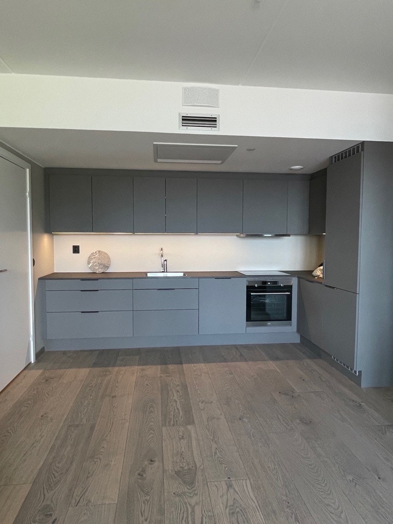 Åpen kjøkkenløsning med god skap plass og integrerte hvitevarer Galleribilde