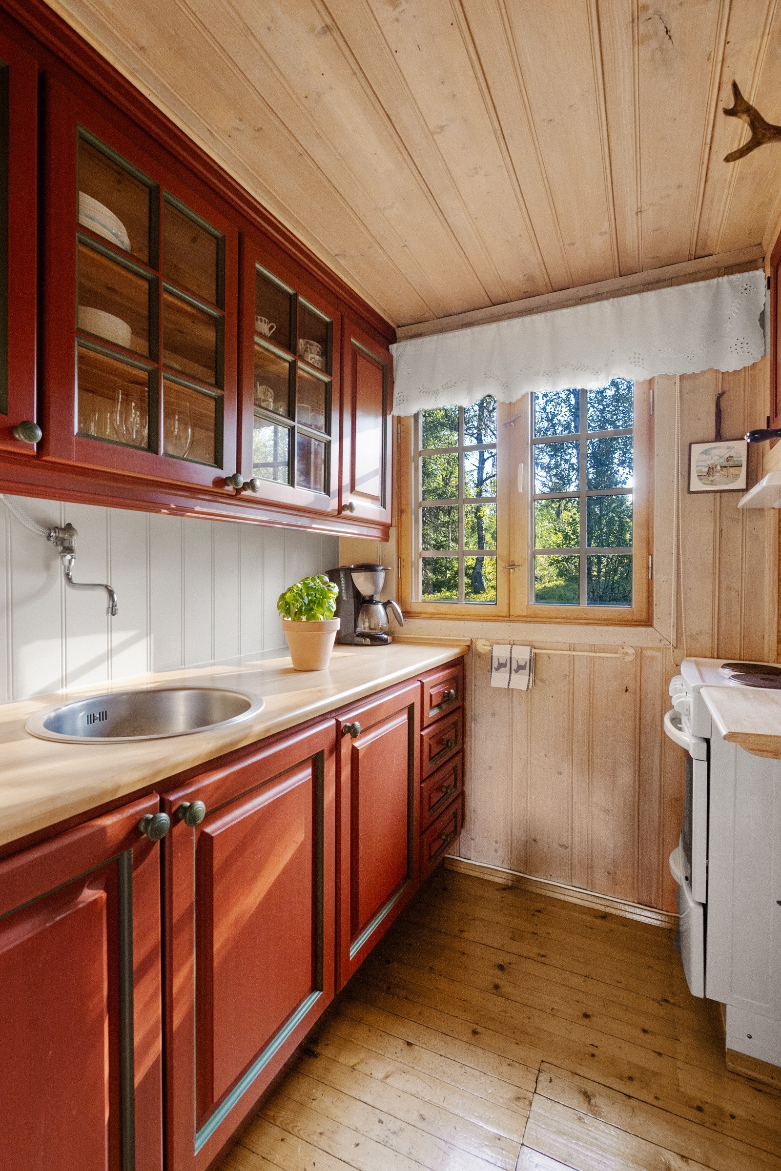 Kjøkkenet har profilerte skapfronter, plass til komfyr og nedfelt vask i benkeplate. Galleribilde