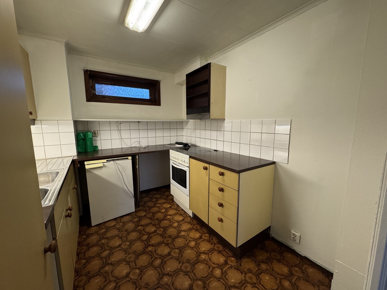 Kjøkken med eldre standard med frittstående hvitevarer. Galleribilde