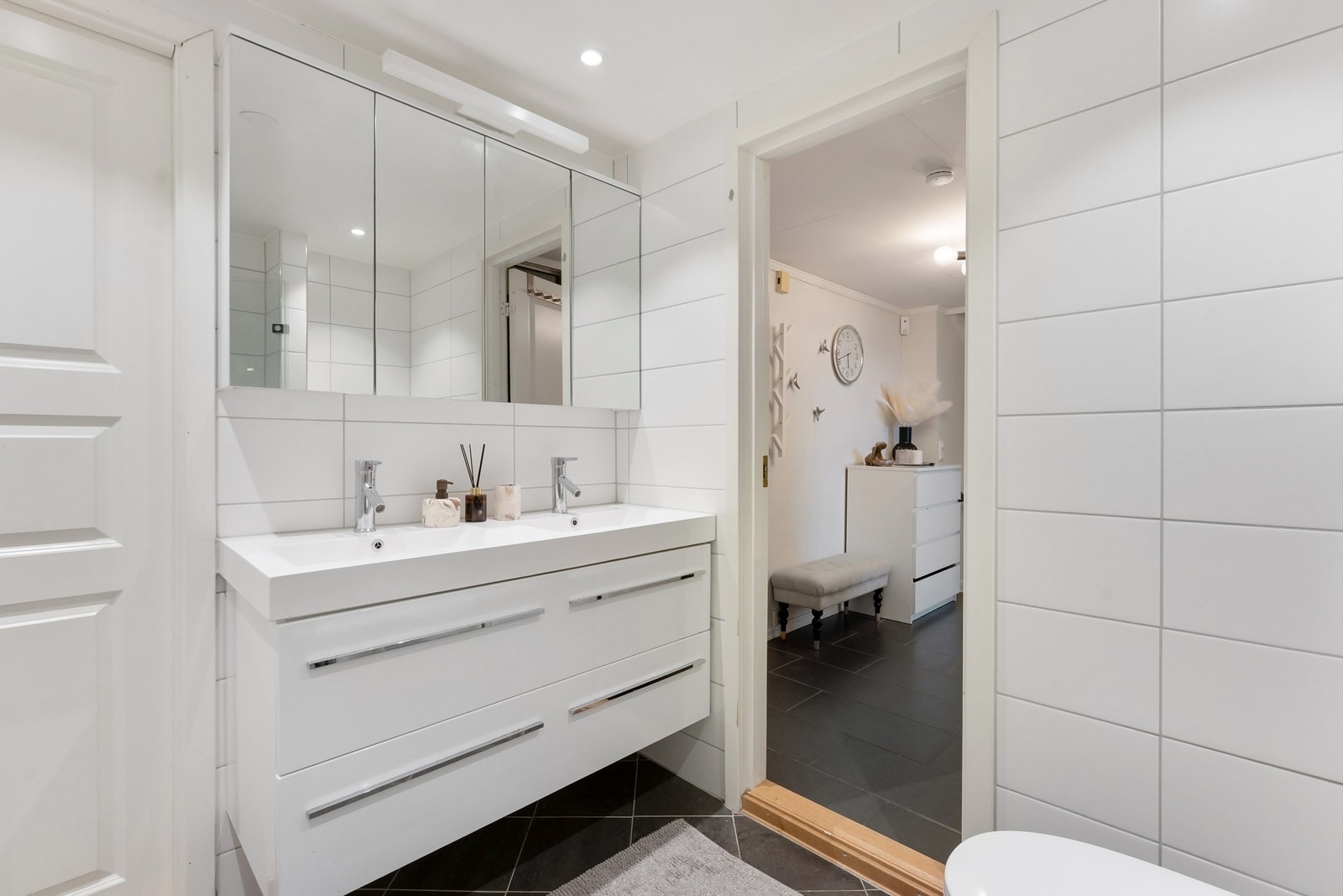 Pent baderom fra 2013 med fliser på gulv med gulvvarme, fliser på vegger og malt himling med downlights Galleribilde