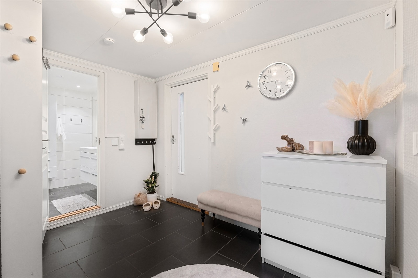 Boligen har en romslig entre med direkte tilgang til bad og til det store kjøkkenet Galleribilde