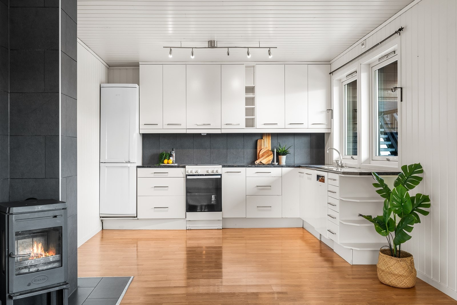 Kjøkkenet er moderne med stilrene, hvite fronter Galleribilde