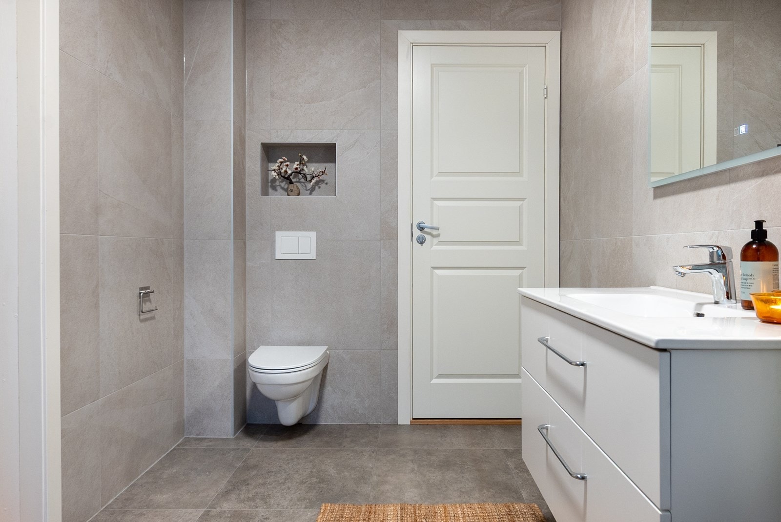 Badet i første etasje ble smakfullt renovert i 2025, og i samme forbindelse ble vann- og avløpsrør fornyet. Store, grå naturfliser på vegger og gulv gir et moderne, men varmt uttrykk. Galleribilde