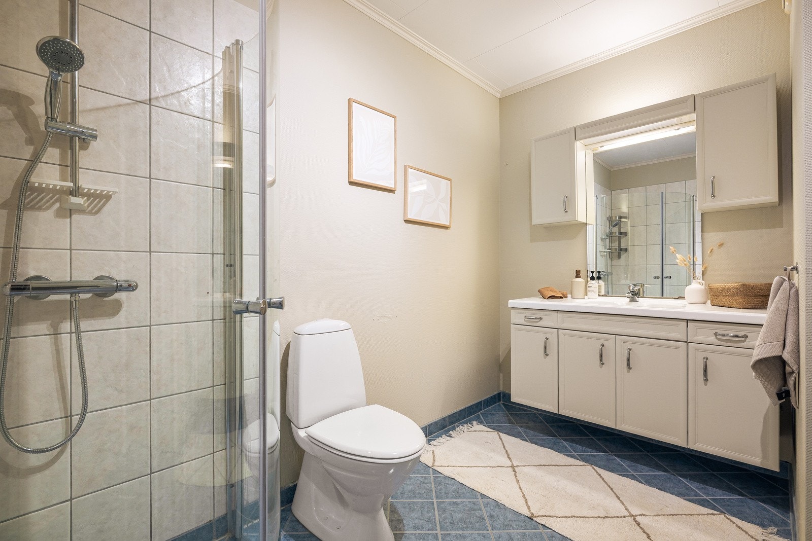 Badet på 5,7 kvm er fra byggeår og har varmekabler i gulv og baderomsmøbel med mye oppbevaringsplass. Galleribilde