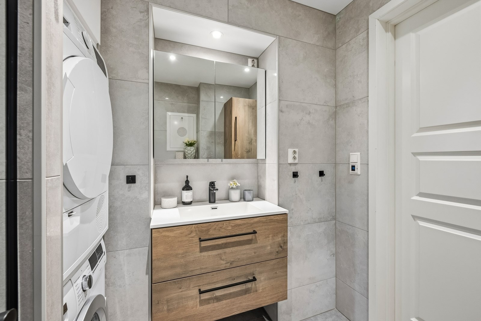 Badet er utstyrt med servantskap med glatte, folierte fronter og heldekkende servant, speilskap på vegg over servant samt veggmontert toalett. Galleribilde