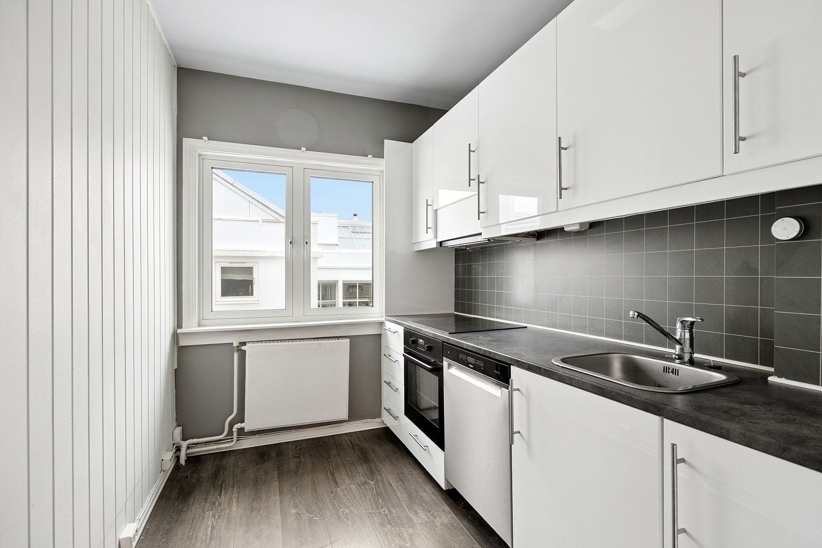 Separat kjøkken med kombiskap, stekeovn, platetopp og oppvaskmaskin Galleribilde