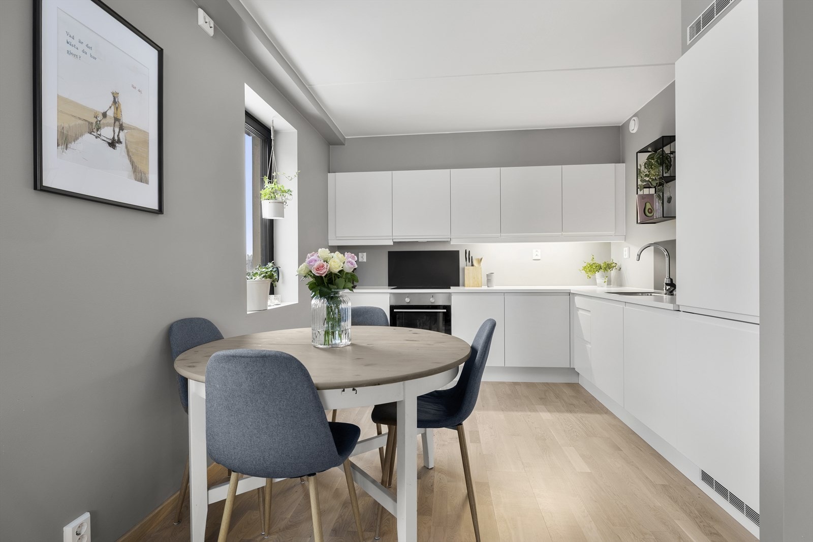 Kjøkkenet er lyst og delikat med hvite, slette fronter og lys benkeplate. Galleribilde